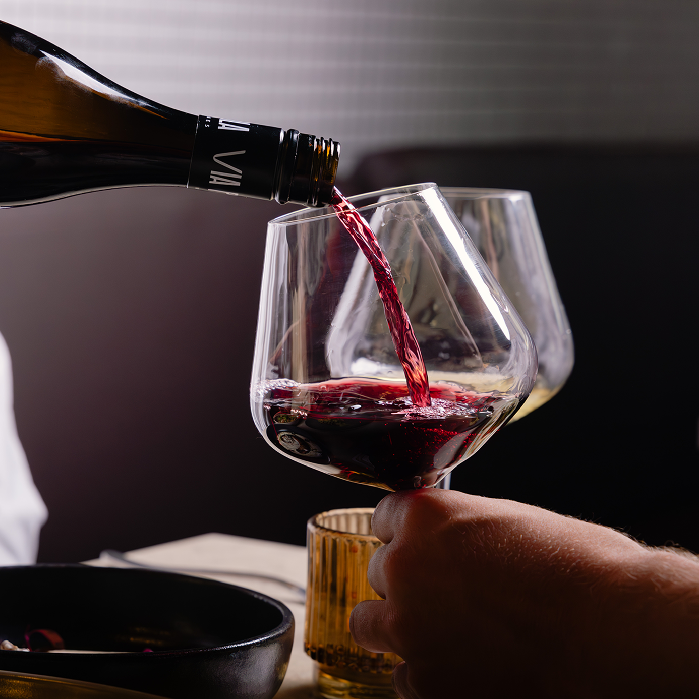 The vibrant colours of a premium red wine being poured